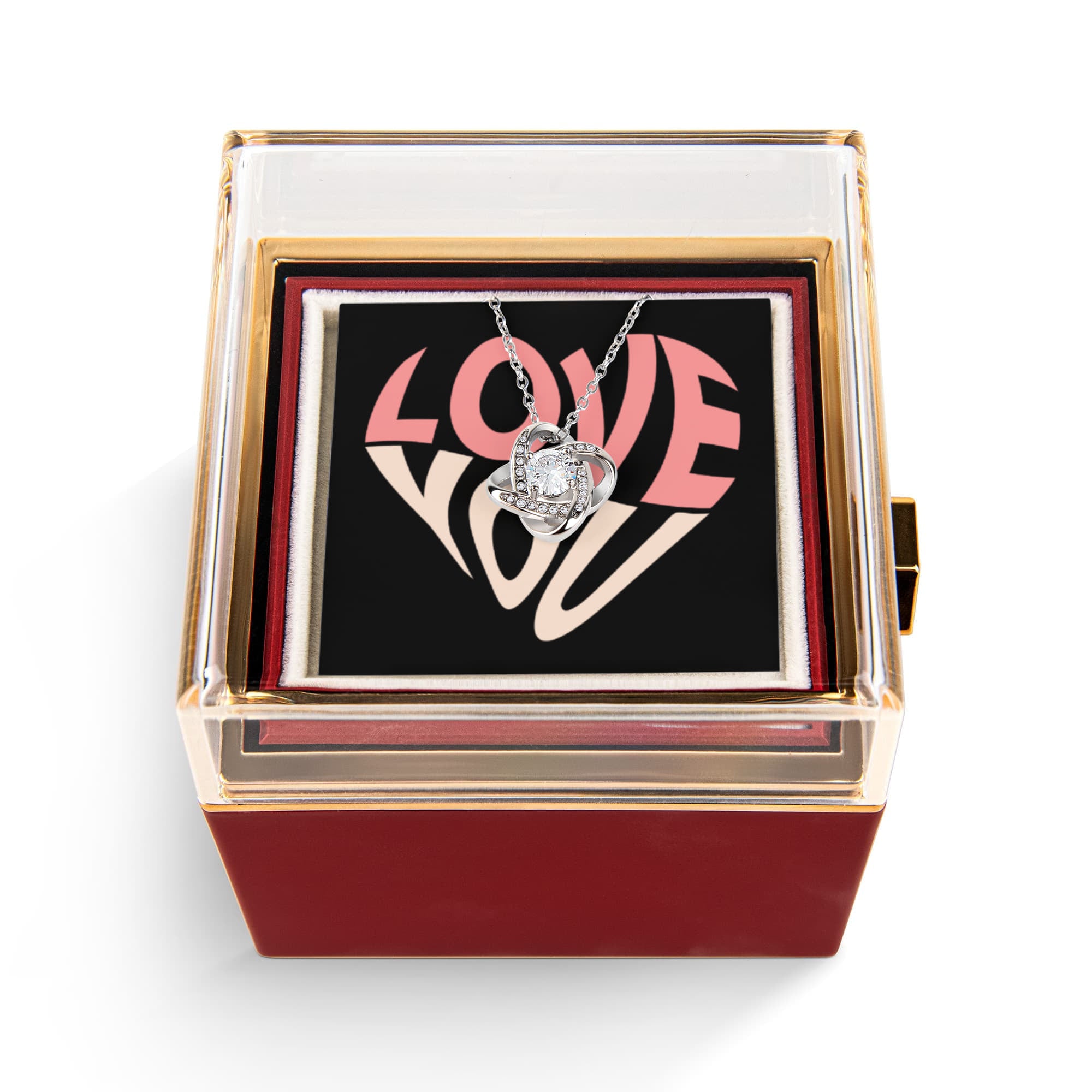 Imagine her reaction as she receives this beautiful Love Knot Necklace. Representing an unbreakable bond between two souls, this stunning pendant is adorned with premium cubic zirconia crystals, making it a timeless symbol of love and devotion. The luxurious box, featuring a meticulously preserved rose that never fades, adds an extra touch of love. With a simple turn of the gold knob, her breathtaking gift is revealed—making it the perfect sentimental gift for that special someone.