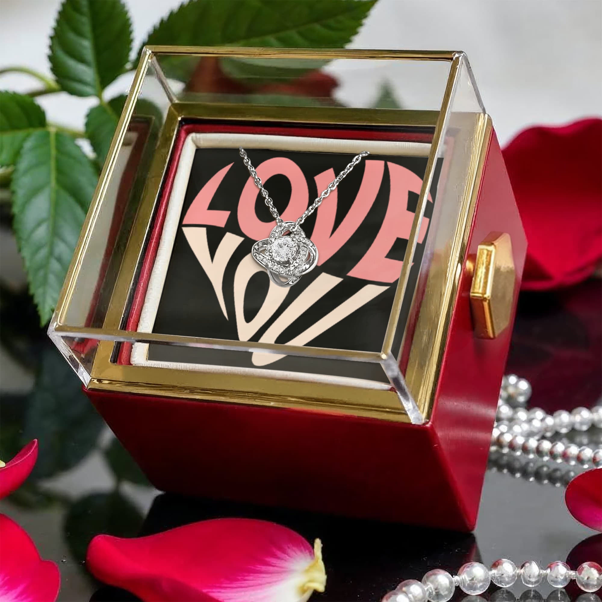 Imagine her reaction as she receives this beautiful Love Knot Necklace. Representing an unbreakable bond between two souls, this stunning pendant is adorned with premium cubic zirconia crystals, making it a timeless symbol of love and devotion. The luxurious box, featuring a meticulously preserved rose that never fades, adds an extra touch of love. With a simple turn of the gold knob, her breathtaking gift is revealed—making it the perfect sentimental gift for that special someone.