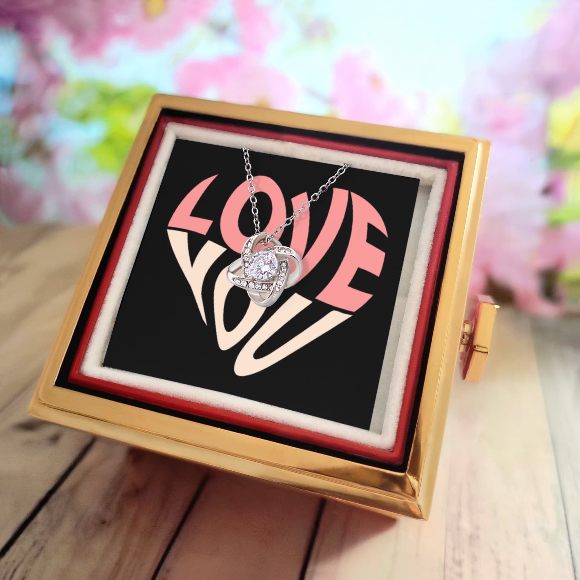 Imagine her reaction as she receives this beautiful Love Knot Necklace. Representing an unbreakable bond between two souls, this stunning pendant is adorned with premium cubic zirconia crystals, making it a timeless symbol of love and devotion. The luxurious box, featuring a meticulously preserved rose that never fades, adds an extra touch of love. With a simple turn of the gold knob, her breathtaking gift is revealed—making it the perfect sentimental gift for that special someone.