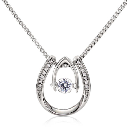 Hand crafted details make this necklace a stand out. This versatile necklace is dipped in white gold and set with shimmering crystals. A dancing center Cubic Zirconia is suspended from two fine points and is designed so as to not touch the skin but continually move in a vibrating fashion.